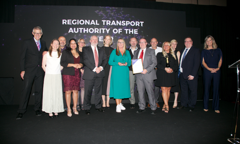 Group of 15 people, most of them Transport for West Midlands team, on stage to collect the Transport Authority of the Year award