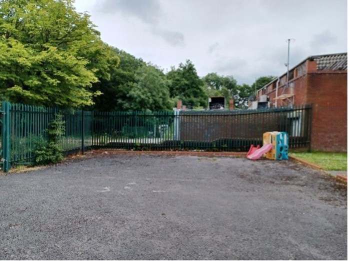A disused area of hard-standing with a fence surrounding it